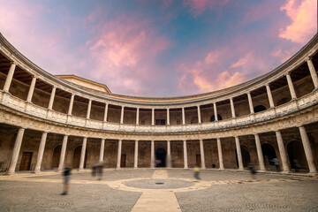 Fototapeta premium Interior of the circular courtyard of the Renaissance-style Palace of Carlos V within the grounds of The Alhambra, Granada, Spain with tourists in motion