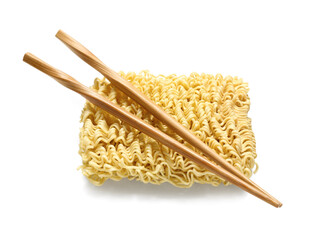Raw instant noodles and wooden chopsticks on white background