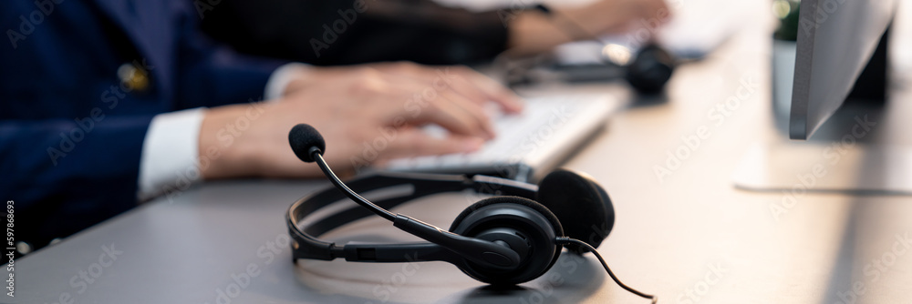 Aufkleber panorama focus headset on call center workspace desk with blur background of operator team or telesa