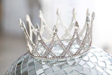Beautiful crown on disco ball, closeup. Prom concept
