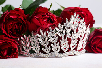 Beautiful tiara with roses on white table, closeup. Prom concept