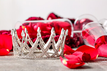 Beautiful crown with rose petals on grunge table, closeup. Prom concept