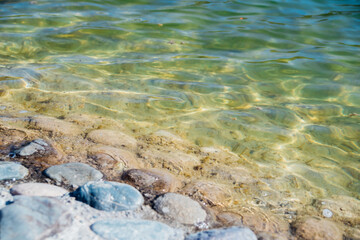 Waves on the seashore. A clear sunny day. Clear, clean sea water. Holidays on the coast. Natural background and texture.
