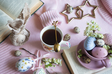 A cup of hot coffee on a festive Easter table with colored eggs.