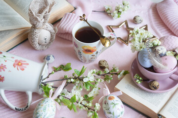 A cup of hot coffee on a festive Easter table with colored eggs.