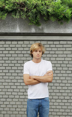 Young man  standing near a brick wall