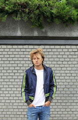 Fototapeta na wymiar Young man standing near a brick wall