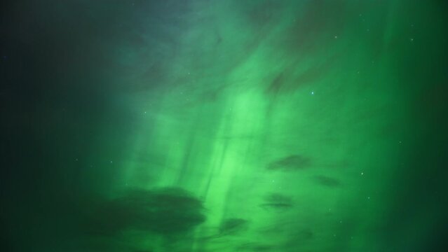 The sky lit with bright green color of Northern Lights (Aurora Borealis). Timelapse. 