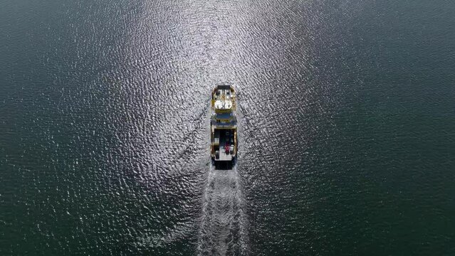 High-angle aerial view of a ferry vessel in a sea carrying vehicles, sea transport ship