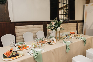 Festive table setting with olive napkins and greenery branches