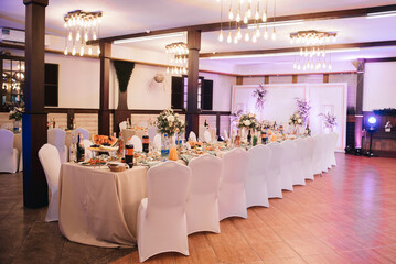 Large table decorated for the event with white tablecloths and chair covers