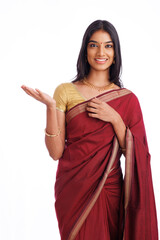 Beautiful Indian young woman in traditional saree and greeting isolated on white.