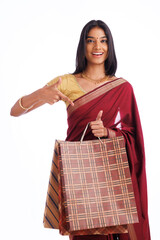 Beautiful Indian traditional woman holding shopping bags and smiling