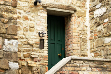 Fototapeta na wymiar Green wooden doors of an old stone mediterranean house
