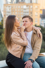 Beautiful happy young loving couple on a surprise date on a Saint Valentine's Day. Romantic date on the rooftop, summertime. Young man and beautiful girl. Newlyweds on honeymoon. Golden hour
