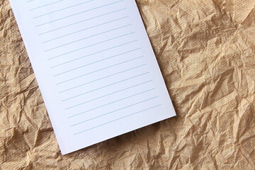 white note paper sheets on brown wrinkled crumpled paper texture background with copy space  