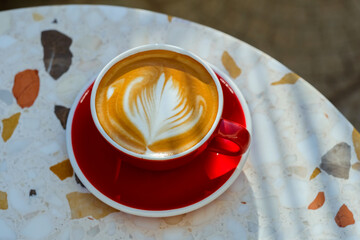 Cup of coffee on marble table . Mug of Latte with art. Natural light and shadow.