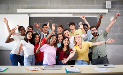 Portrait of a cheerful group of students celebrating in class looking at the camera. Happy Young...