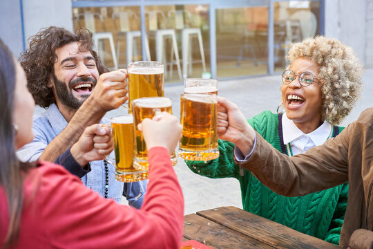 Group of friends having fun during a party. Happy People laughing and toasting beer. High quality photo