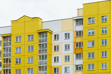 Multicoloured high-rise residential buildings in affluent areas. Multi-apartment multi-storey building with a multicolored facade against a blue sky background. Modern design. Buying a home.