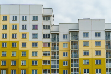 Multicoloured high-rise residential buildings in affluent areas. Multi-apartment multi-storey building with a multicolored facade against a blue sky background. Modern design. Buying a home.