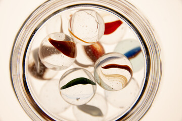 Macrofotografía de esferas de vidrio transparentes adentro de un frasco transparente con colores en su interior