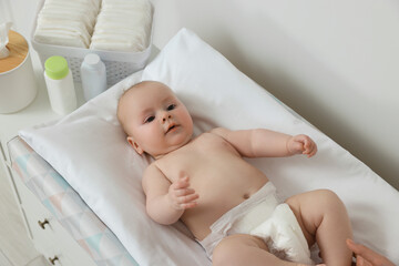 Mother with her baby at changing table indoors, closeup