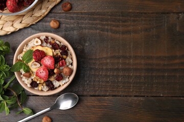 Oatmeal with freeze dried fruits, nuts and mint on wooden table, flat lay. Space for text