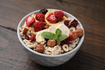 Oatmeal with freeze dried fruits, nuts and mint on wooden table