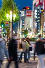 Happy Asian woman friends walking and shopping together at Shibuya district, Tokyo, Japan in evening. Attractive girl enjoy and fun outdoor lifestyle walking and travel city street on holiday vacation