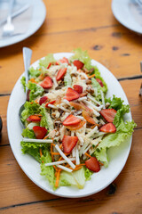 mixed strawberry salad in vinaigrette sauce consist of turnip, carrots, lettuce, bacon and strawberry