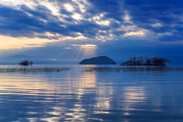 竹生島に光芒が降り注ぐ琵琶湖の夕焼け情景