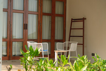 Two chairs in front of balcony at room for long staying on vacation, decorate plants and trees