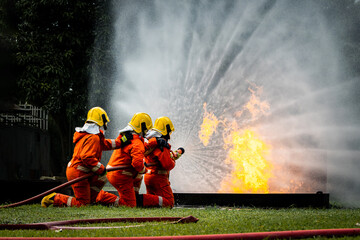 Firefighter Concept. Fireman using water and extinguisher to fighting with fire flame. firefighters...