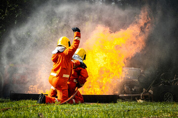 Firefighter Concept. Fireman using water and extinguisher to fighting with fire flame. firefighters...