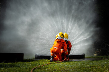 Firefighter Concept. Fireman using water and extinguisher to fighting with fire flame. firefighters...