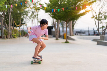 asian child skater or kid girl playing skateboard or ride carving surf skate by barefoot to fun in...