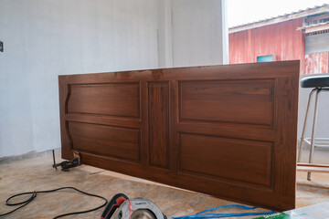 Carpenter man working on wooden door in new house building