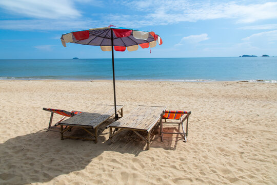 beach chairs on white sand beach on sea and blue sky. Chairs and umbrella. Tropical summer holiday