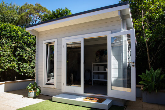 Backyard hamptons grey garden shed storage tiny house window doors grass trees garage