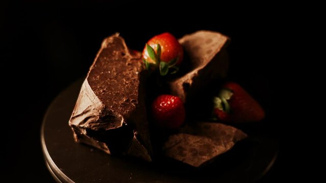 Red straberry with a dark chocolate on a black background 4k