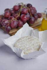 Camembert cheese , grape and oil on table 