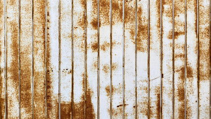 Iron fence wall. Old rusty galvanized corrugated white roofing sheet. The texture is made of corrugated iron steel.