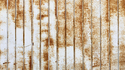 The texture is made of corrugated iron steel. Old rusty galvanized corrugated white roofing sheet. Iron fence wall.