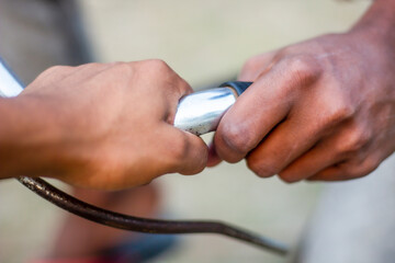 Two people are holding the handle of a bicycle and the background is behind