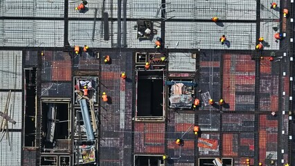 Aerial view of construction site. Construction workers are busy working. High angle view.