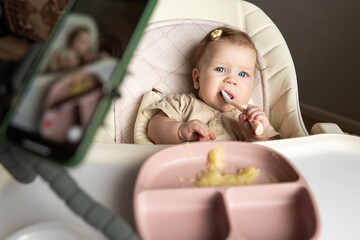 Mom-blogger removes the first lure of her child. Feeding the baby.A baby with a spoon in his mouth...