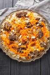 Traditional Kabuli Pulao with Sweet Carrot and raisins topping closeup on the plate. Vertical top...
