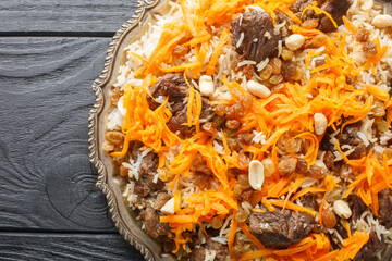 Afghan national dish Kabuli Pulao rice pilaf with lamb and raisin, carrot, nut, spices closeup on...