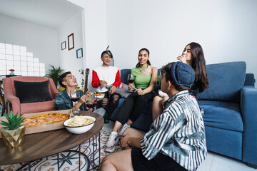 Group of latin LGBT friends eating pizza and drinks at home in Mexico, Hispanic homosexual and lgbtq community in Latin America